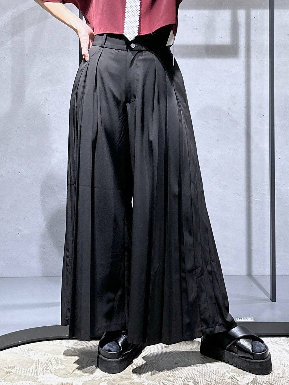 ブラック系のサンダル、ブラック系のその他パンツ、レッド系のシャツ/ブラウスを着用したレディースの夏コーディネートの7枚目の写真