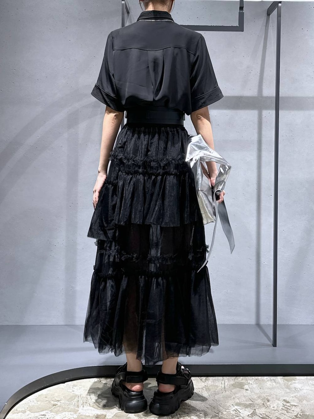 ブラック系のシャツ/ブラウス、ブラック系のサンダル、シルバー系のトートバッグを着用したレディースの夏コーディネートの3枚目の写真