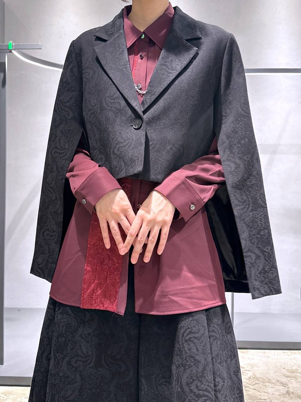 ブラック系のブーツ、ブラック系のテーラードジャケット、レッド系のシャツ/ブラウスを着用したレディースの秋コーディネートの5枚目の写真