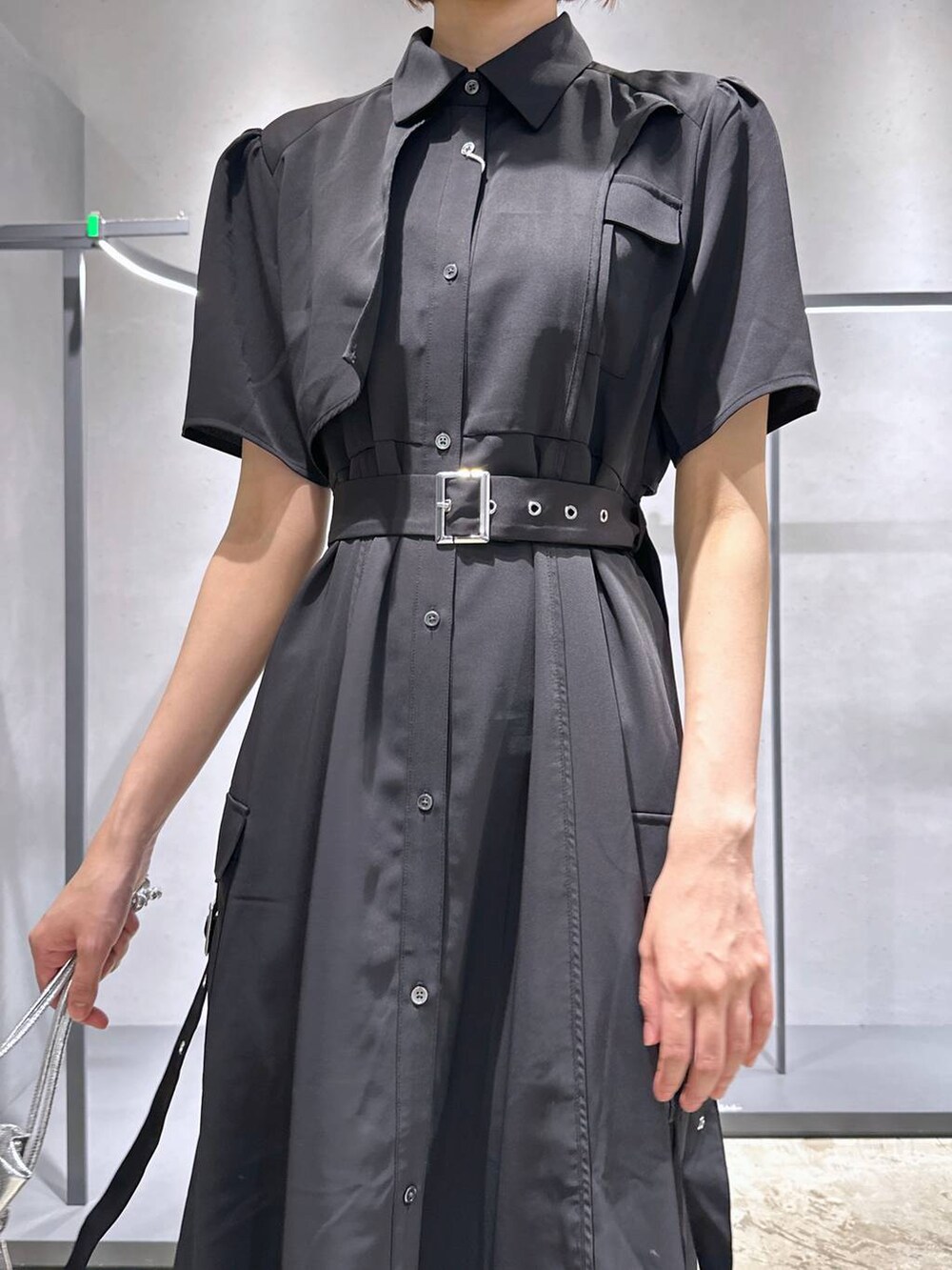 ブラック系のサンダル、ブラック系のワンピース、シルバー系のショルダーバッグを着用したレディースの夏コーディネートの5枚目の写真