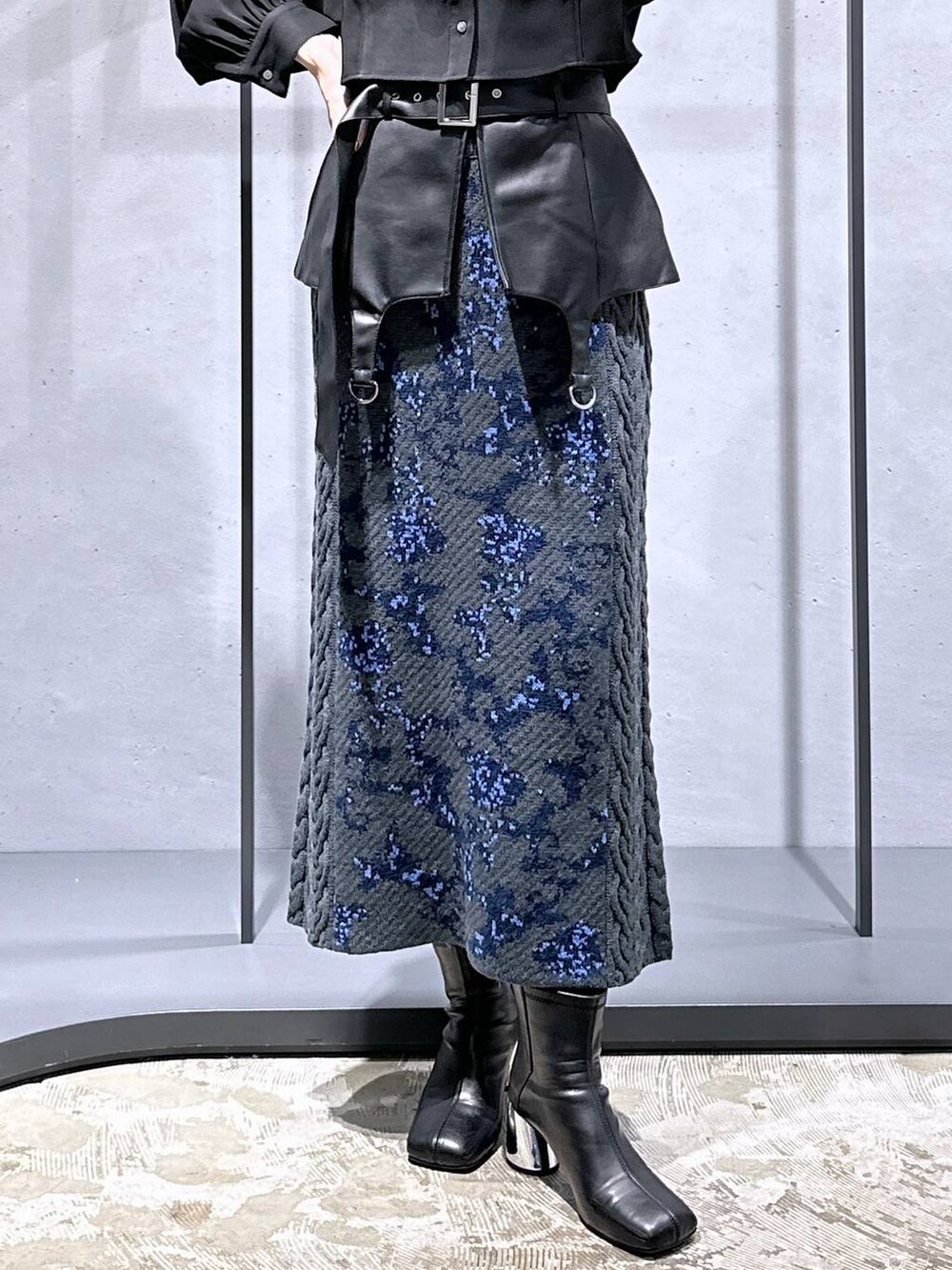 グレー系のスカート、ブラック系のブーツ、ブラック系のシャツ/ブラウスを着用したレディースの秋コーディネートの6枚目の写真