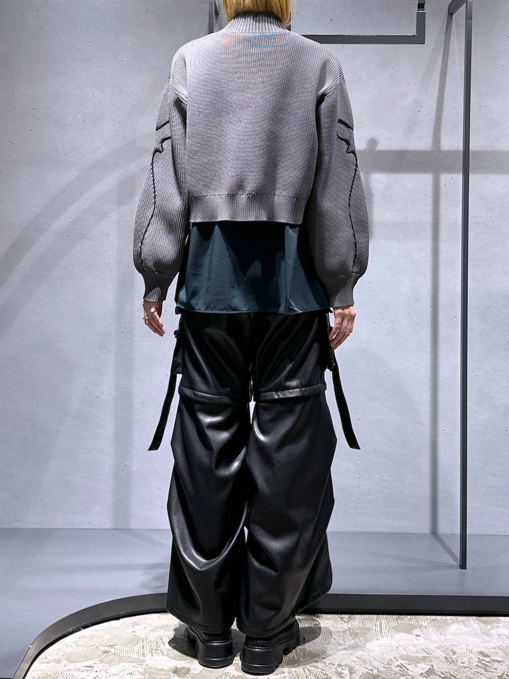 ブラック系のカーゴパンツ、ブラック系のブーツ、グレー系のニット/セーターを着用したレディースの冬コーディネートの3枚目の写真