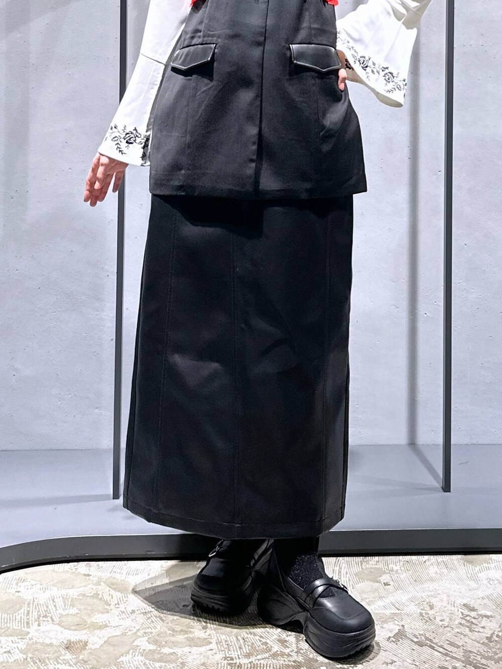 ブラック系のブーツ、ホワイト系のシャツ/ブラウス、ブラック系のスカートを着用したレディースの秋コーディネートの6枚目の写真