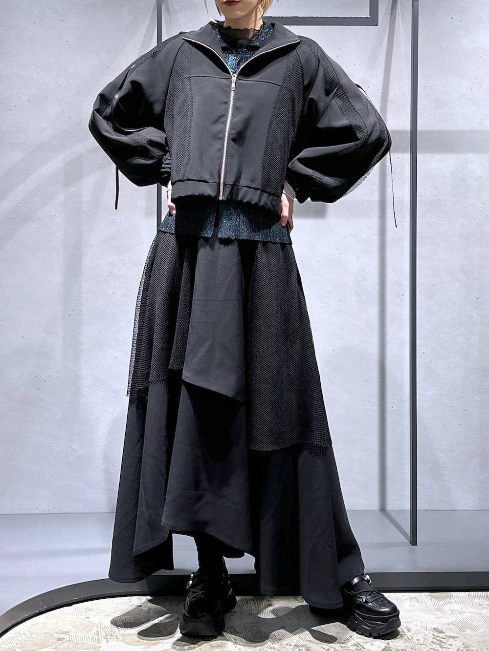 グリーン系のカーディガン/ボレロ、ブラック系のTシャツ/カットソー、ブラック系のスニーカーを着用したレディースの冬コーディネートの4枚目の写真