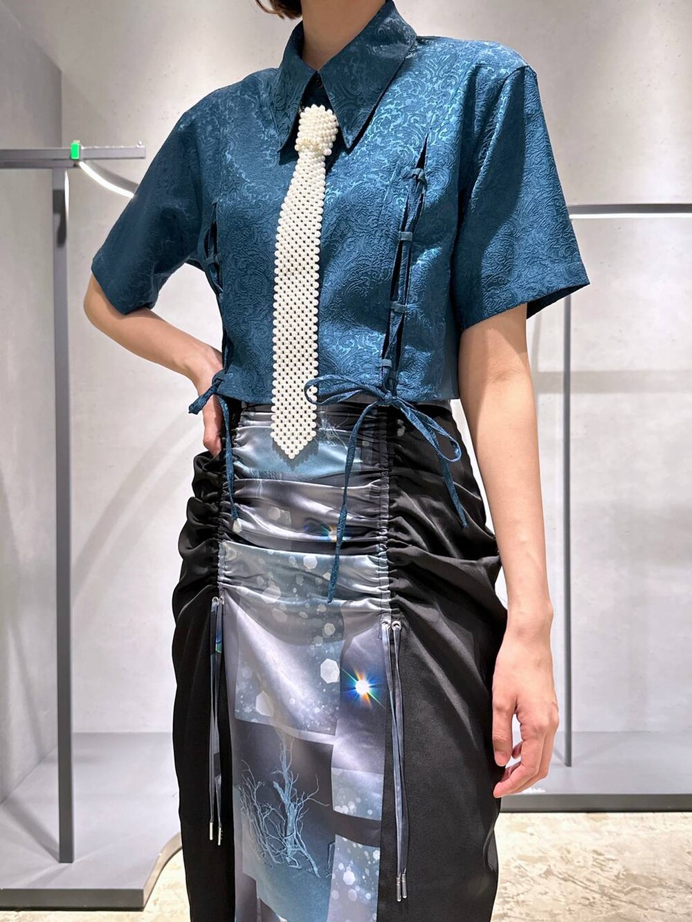 グリーン系のシャツ/ブラウス、ブラック系のサンダル、ブラック系のスカートを着用したレディースの夏コーディネートの2枚目の写真