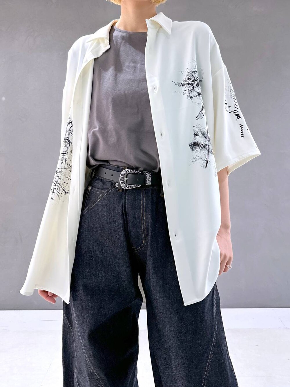 ブラック系のサンダル、ブルー系のデニムパンツ、グレー系のTシャツ/カットソーを着用したレディースの春コーディネートの4枚目の写真