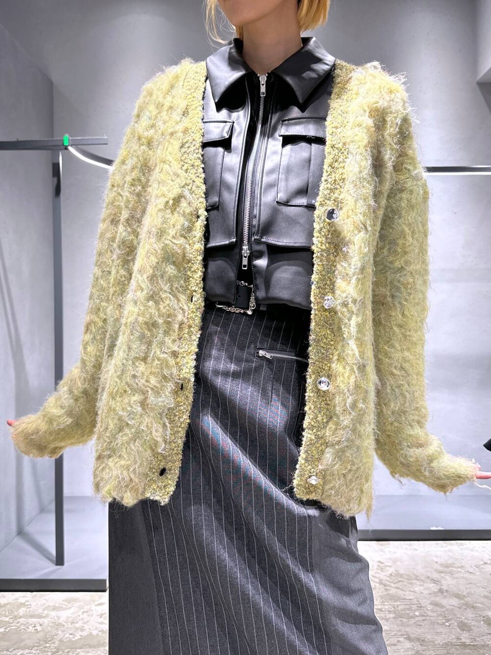 ブラック系のブルゾン、ブラック系のドレスシューズ、イエロー系のカーディガン/ボレロを着用したレディースの秋コーディネートの5枚目の写真