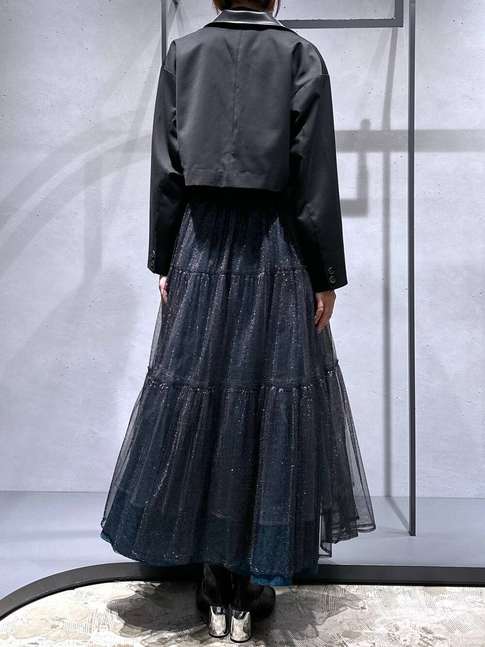 グリーン系のスカート、ブラック系のブーツ、ブラック系のシャツ/ブラウスを着用したレディースの秋コーディネートの3枚目の写真