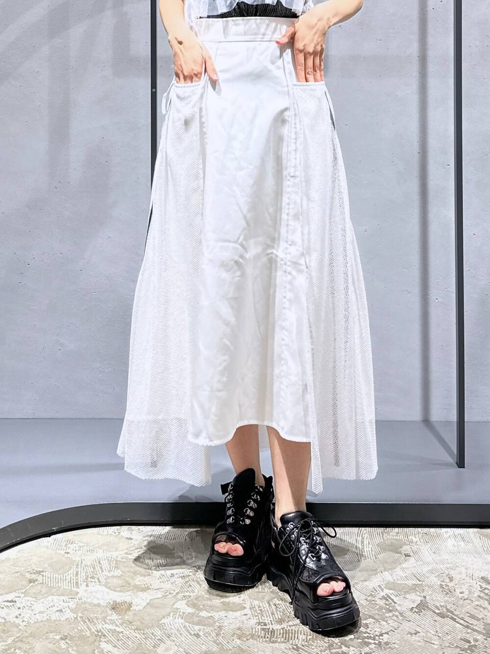 シルバー系のチューブトップ、ブラック系のTシャツ/カットソー、ホワイト系のスカートを着用したレディースの夏コーディネートの6枚目の写真