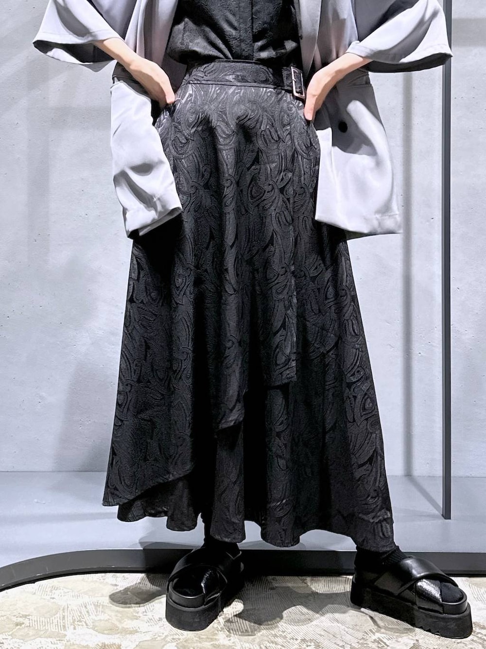 ブラック系のサンダル、ブラック系のスカート、グレー系のテーラードジャケットを着用したレディースの春コーディネートの6枚目の写真