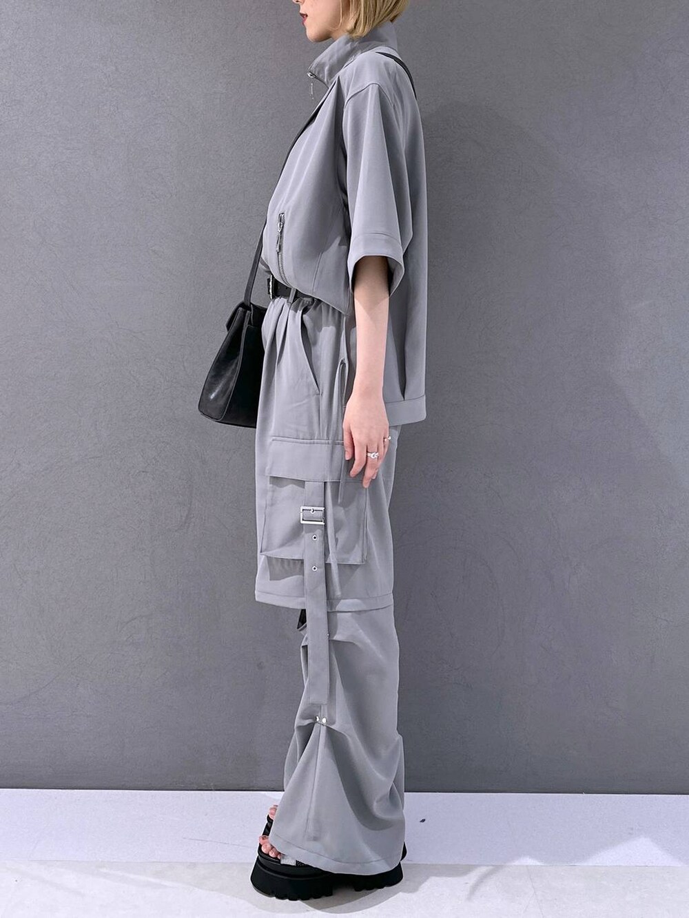 シルバー系のサンダル、グレー系のカーゴパンツ、グレー系のブルゾンを着用したレディースの春コーディネートの2枚目の写真