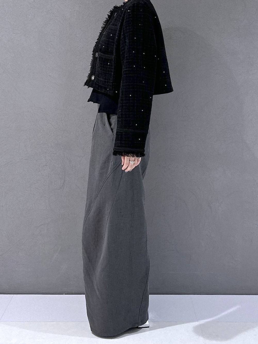 ブラック系のカーディガン/ボレロ、ブラック系のブーツ、グレー系のスラックスを着用したレディースの秋コーディネートの2枚目の写真