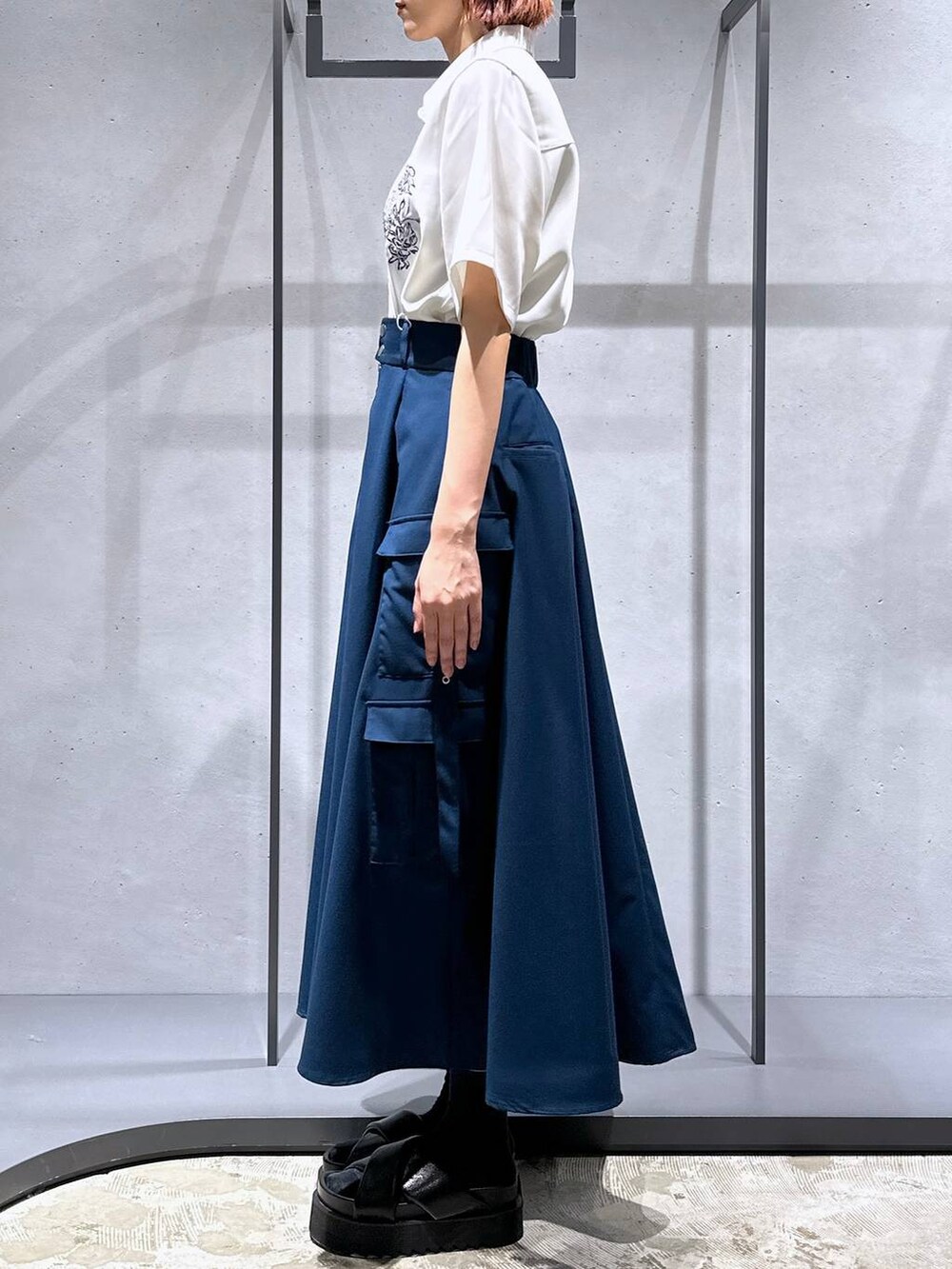 ブラック系のサンダル、ブルー系のスカート、ホワイト系のシャツ/ブラウスを着用したレディースの春コーディネートの3枚目の写真