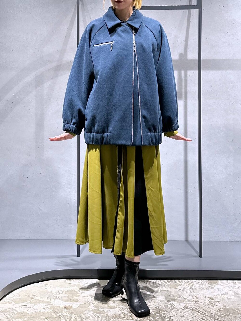 ブラック系のブーツ、ブルー系のブルゾン、イエロー系のワンピースを着用したレディースの冬コーディネートの4枚目の写真