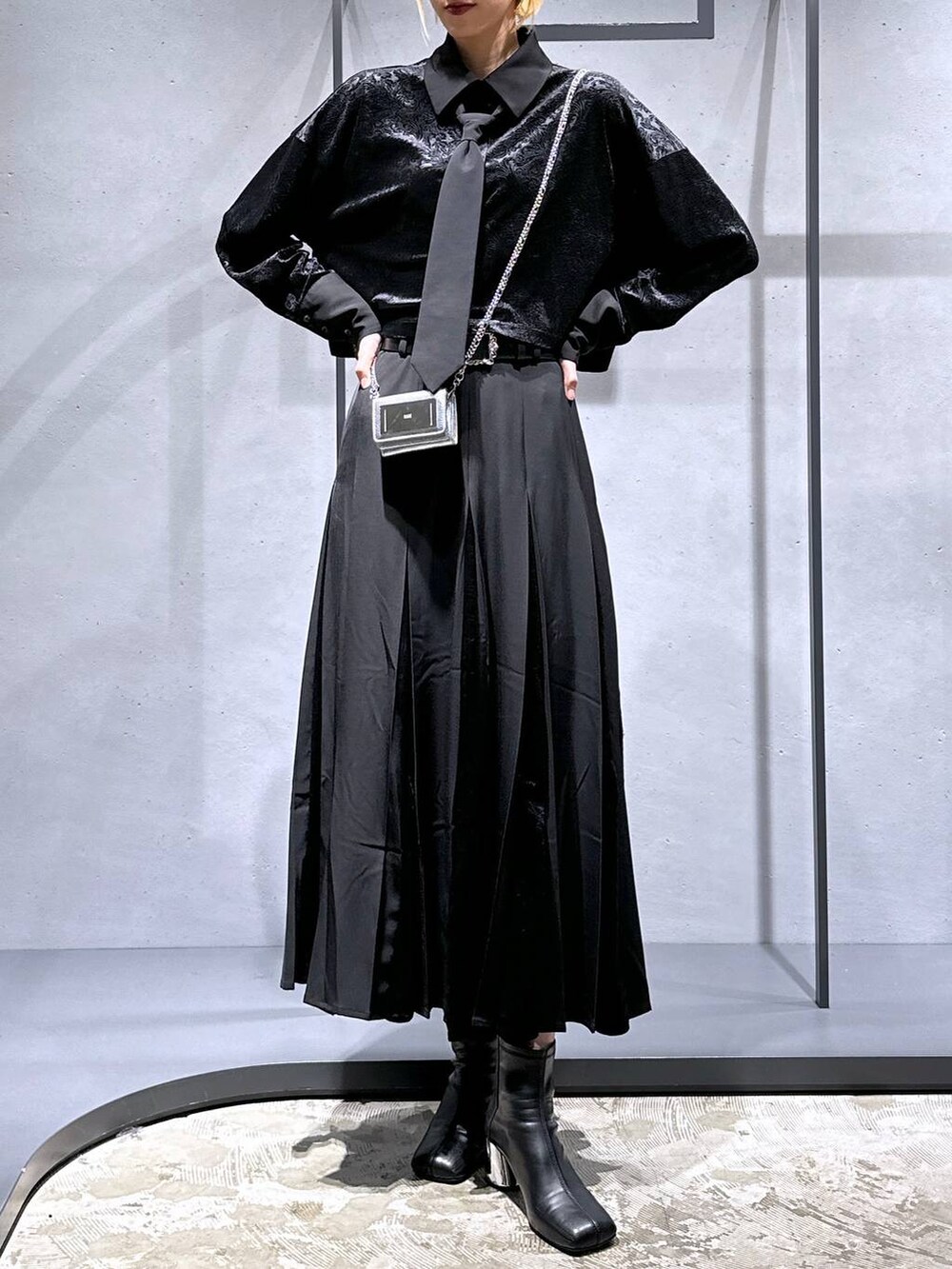 ブラック系のブーツ、ブラック系のシャツ/ブラウス、ブラック系のスカートを着用したレディースの秋コーディネートの4枚目の写真