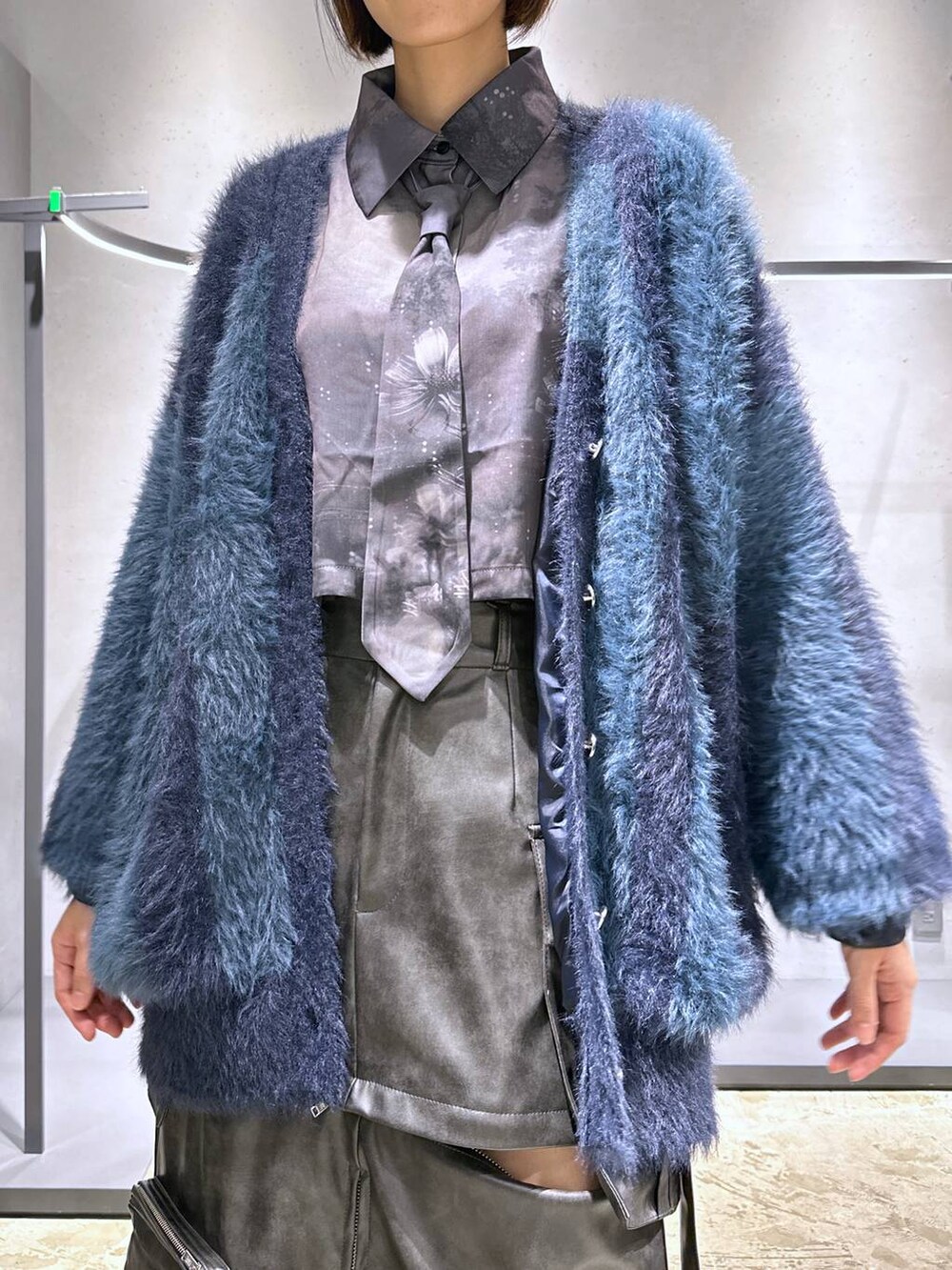 ブルー系のカーディガン/ボレロ、ブラック系のブーツ、ブラック系のシャツ/ブラウスを着用したレディースの秋コーディネートの5枚目の写真