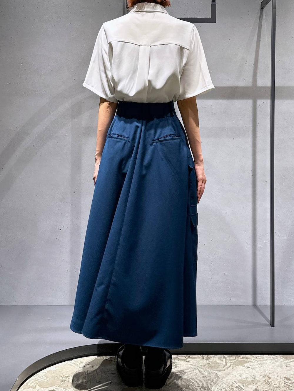 ブラック系のサンダル、ブルー系のスカート、ホワイト系のシャツ/ブラウスを着用したレディースの春コーディネートの4枚目の写真