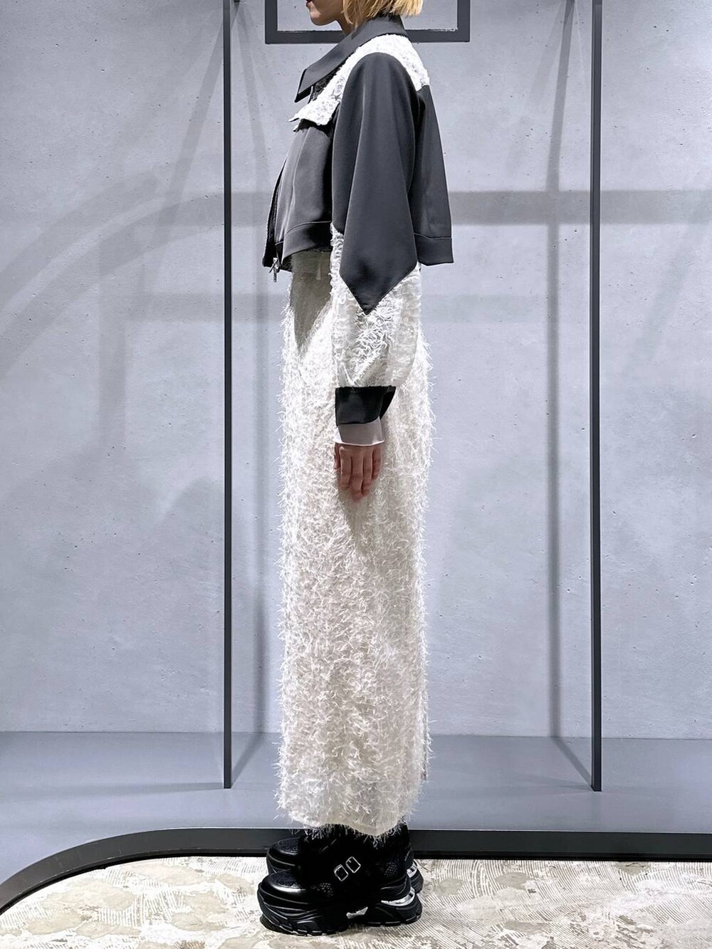 ブラック系のTシャツ/カットソー、ブラック系のスニーカー、ホワイト系のスカートを着用したレディースの冬コーディネートの2枚目の写真