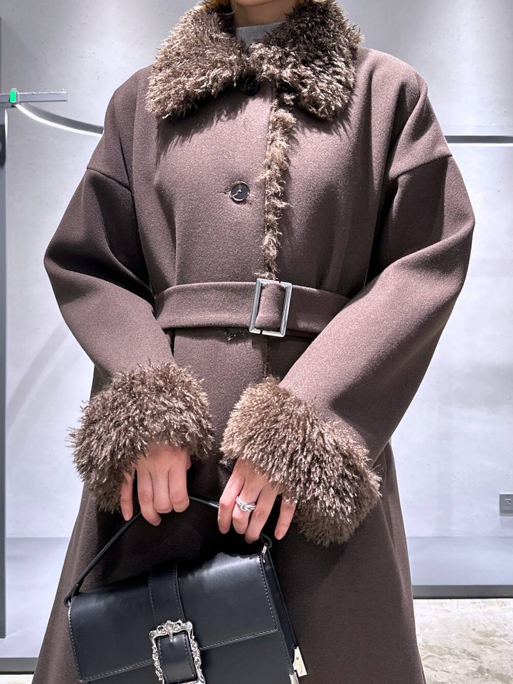 ホワイト系のニット/セーター、シルバー系のブーツ、ブラック系のショルダーバッグを着用したレディースの冬コーディネートの5枚目の写真