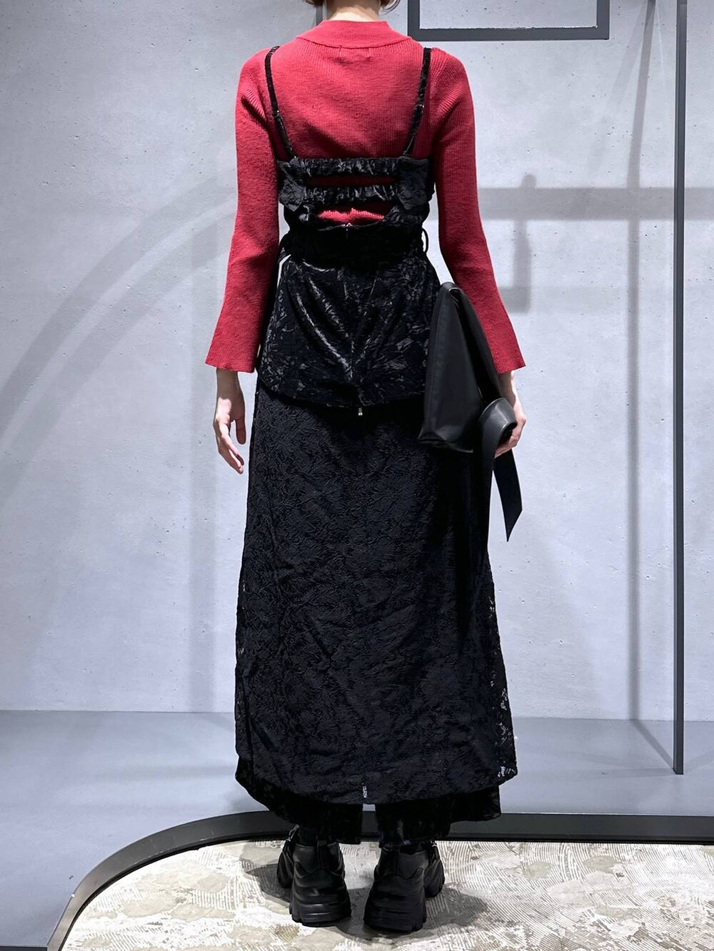 レッド系のニット/セーター、ブラック系のローファー、ブラック系のベストを着用したレディースの夏コーディネートの3枚目の写真