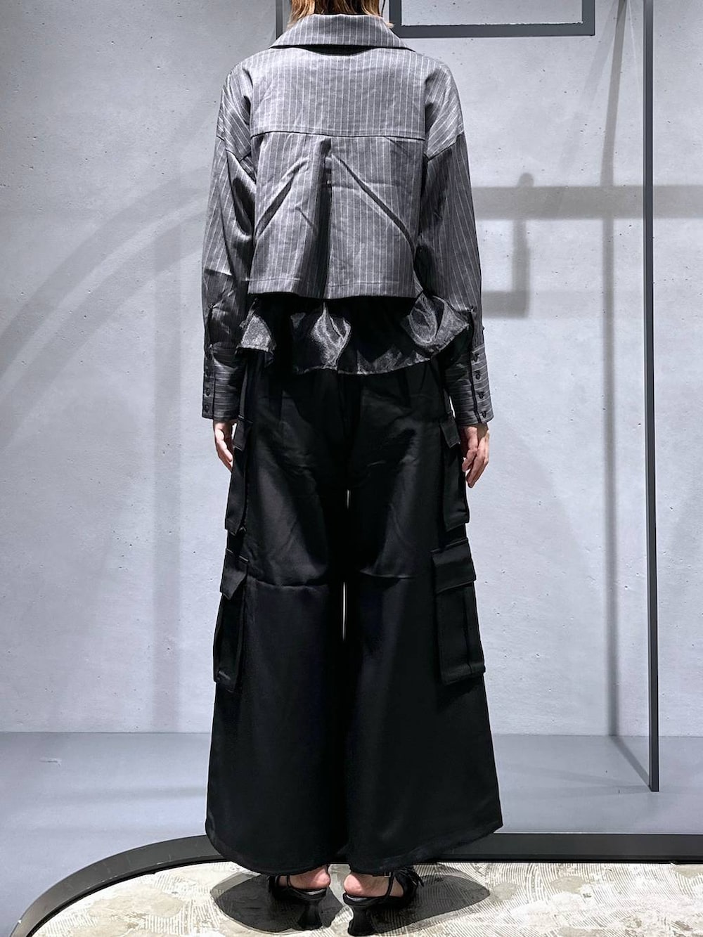 ブラック系のパンプス、ブラック系のベスト、ブラック系のカーゴパンツを着用したレディースの夏コーディネートの3枚目の写真