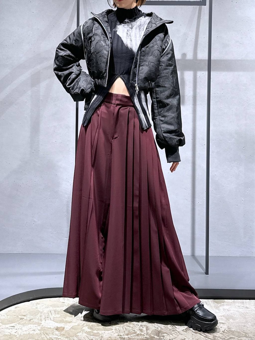 ブラック系のブルゾン、レッド系のその他パンツ、ブラック系のローファーを着用したレディースの秋コーディネートの4枚目の写真