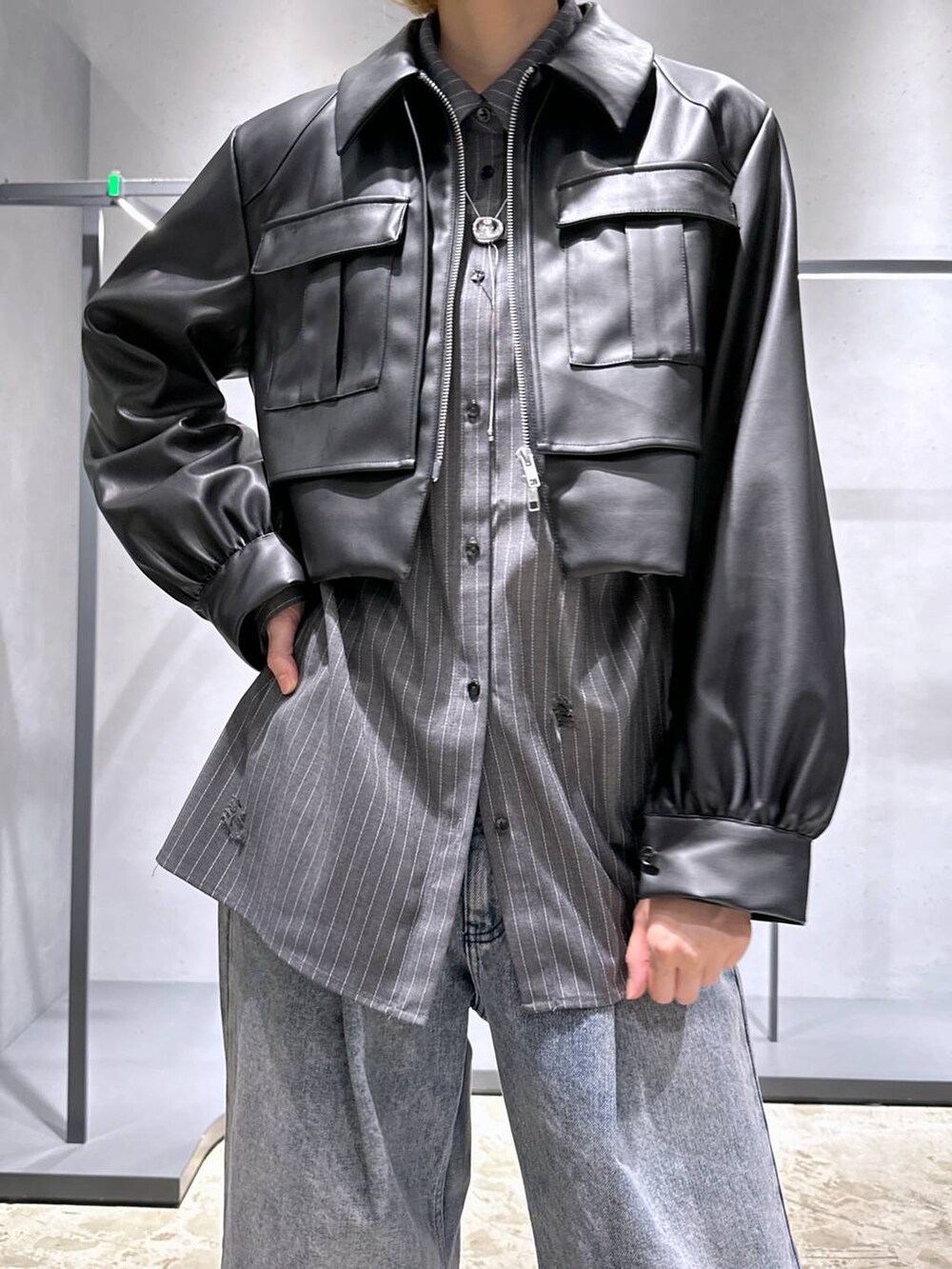 パープル系のデニムパンツ、ブラック系のブーツ、ブラック系のブルゾンを着用したレディースの秋コーディネートの5枚目の写真