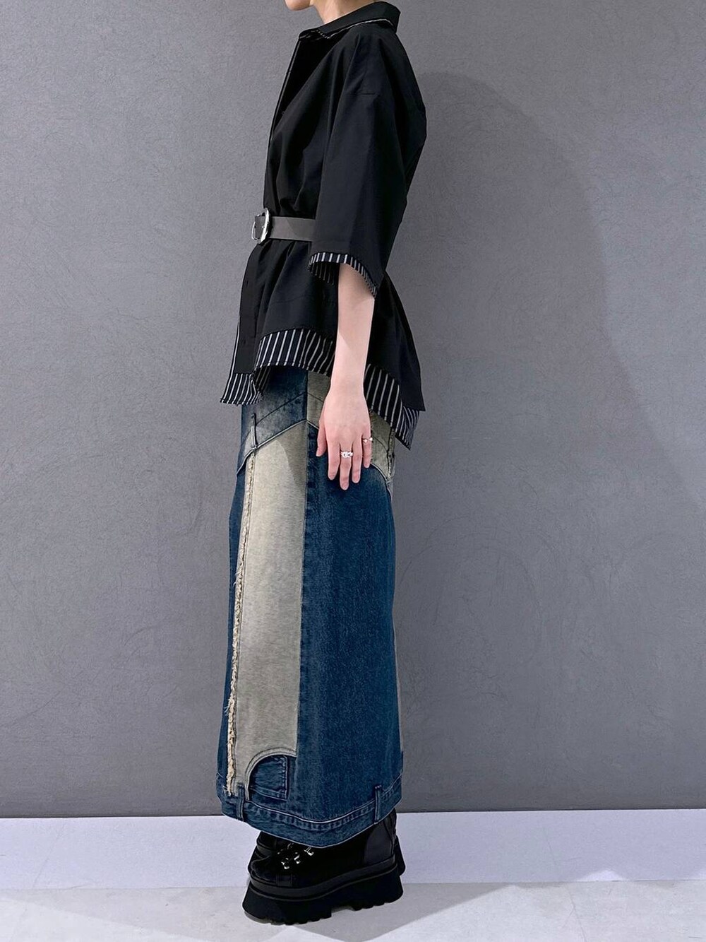 ブラック系のサンダル、ブルー系のデニムスカート、ブラック系のシャツ/ブラウスを着用したレディースの春コーディネートの2枚目の写真