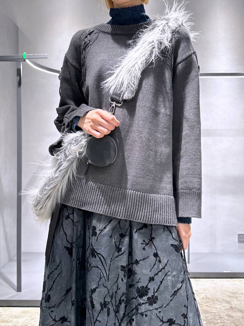ブルー系のTシャツ/カットソー、グレー系のニット/セーター、グレー系のショルダーバッグを着用したレディースの秋コーディネートの5枚目の写真