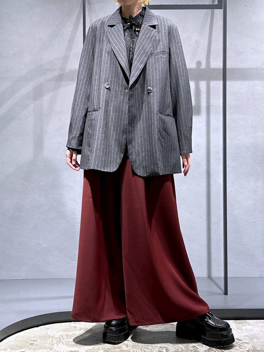 レッド系のその他パンツ、ブラック系のシャツ/ブラウス、ブラック系のドレスシューズを着用したレディースの秋コーディネートの4枚目の写真