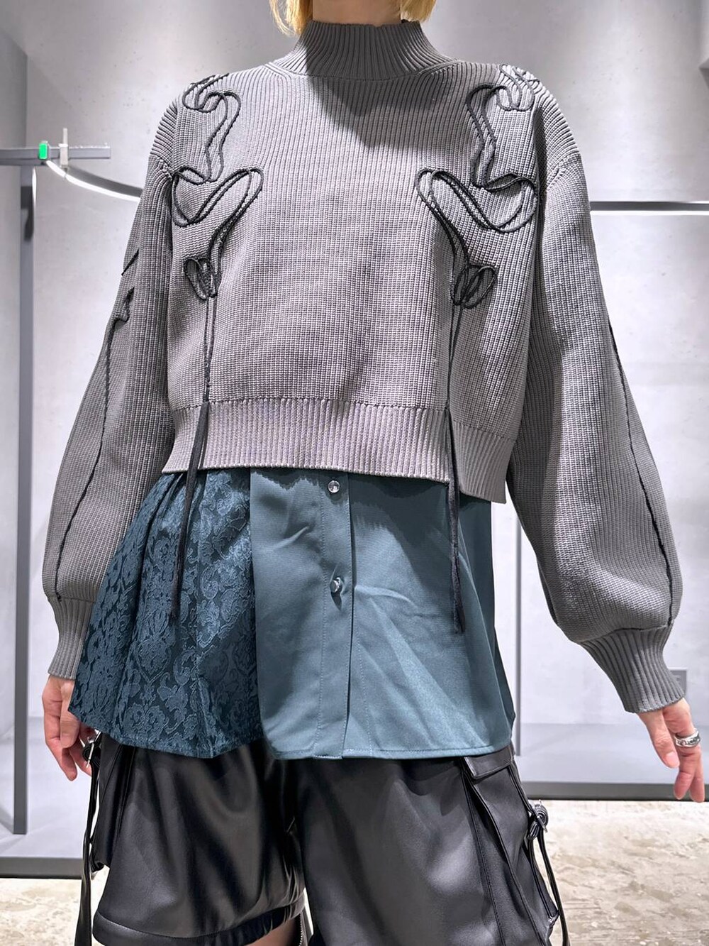 ブラック系のカーゴパンツ、ブラック系のブーツ、グレー系のニット/セーターを着用したレディースの冬コーディネートの5枚目の写真