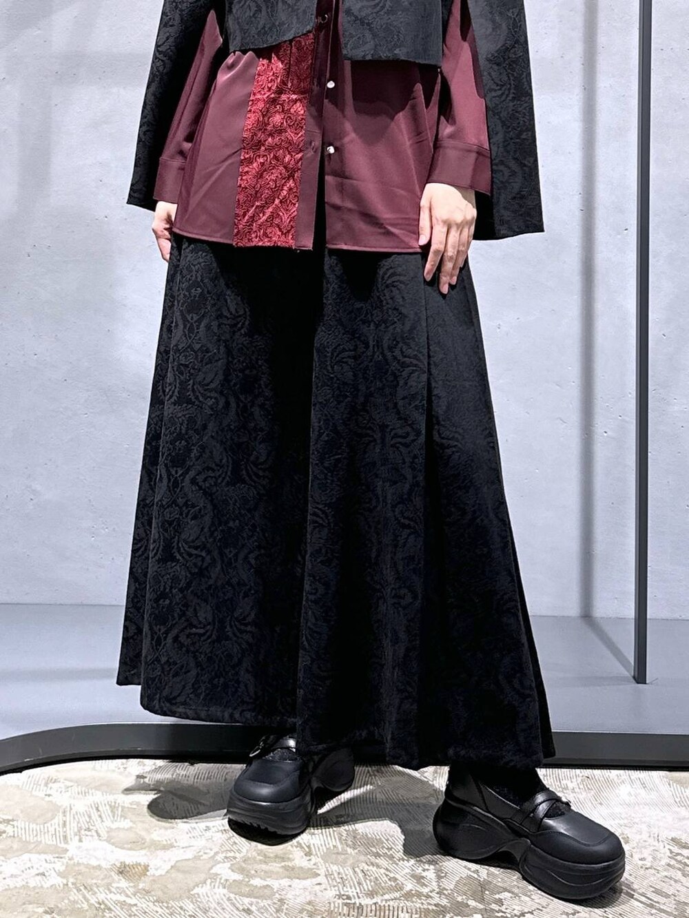 ブラック系のブーツ、ブラック系のテーラードジャケット、レッド系のシャツ/ブラウスを着用したレディースの秋コーディネートの6枚目の写真