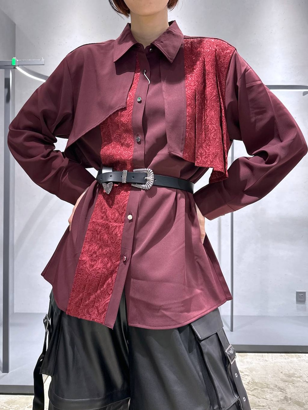 ブラック系のカーゴパンツ、ブラック系のブーツ、レッド系のシャツ/ブラウスを着用したレディースの夏コーディネートの5枚目の写真