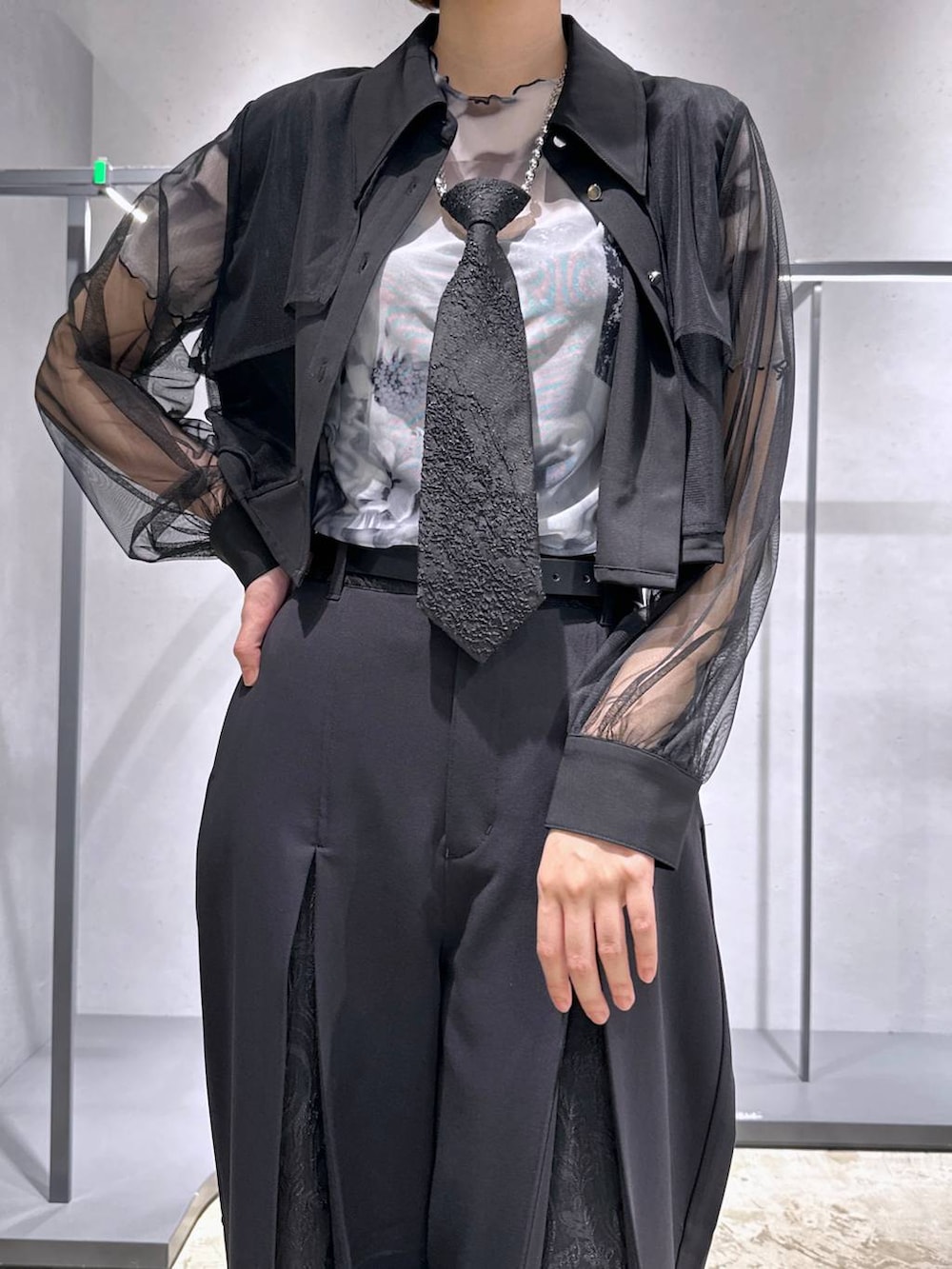 ブラック系のネクタイ、ホワイト系のTシャツ/カットソー、ブラック系のサンダルを着用したレディースの夏コーディネートの7枚目の写真