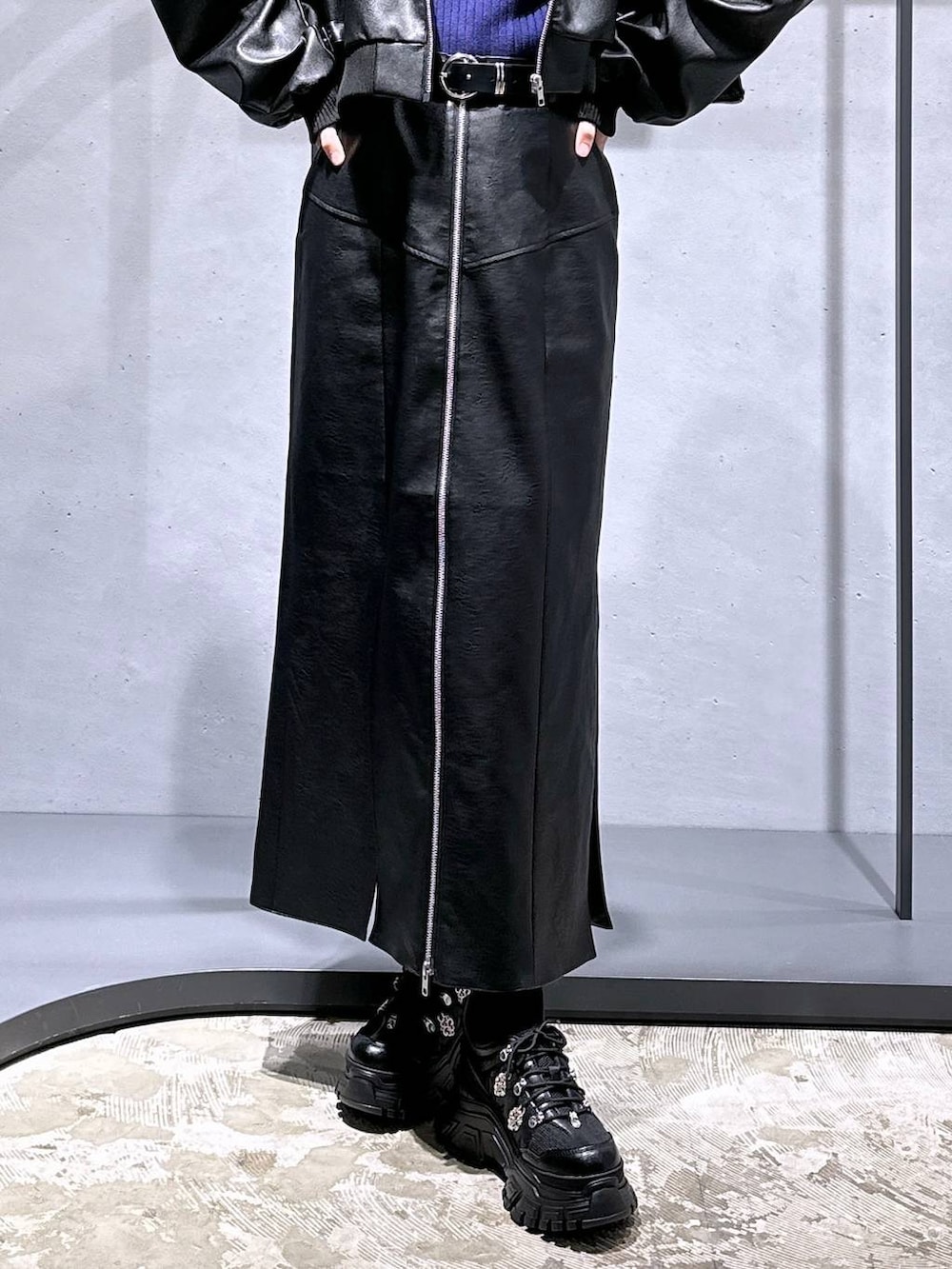 ブラック系のスニーカー、ブラック系のスカート、パープル系のニット/セーターを着用したレディースの冬コーディネートの8枚目の写真