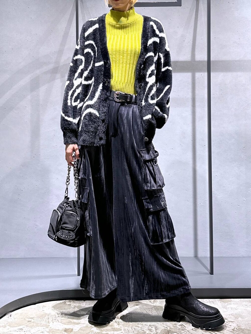 ブラック系のカーディガン/ボレロ、イエロー系のニット/セーター、ブラック系のショルダーバッグを着用したレディースの秋コーディネートの4枚目の写真