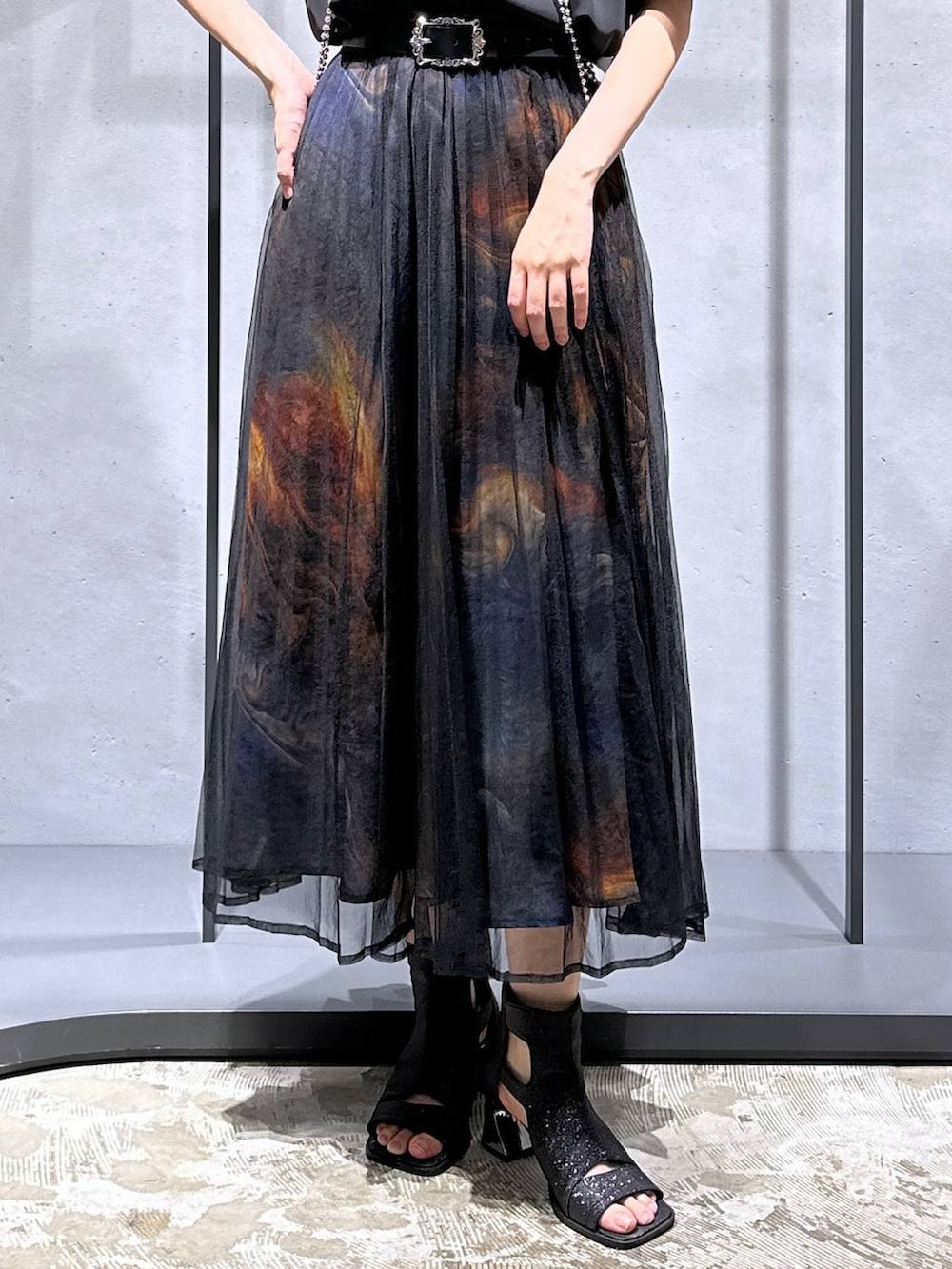 ブラック系のシャツ/ブラウス、ブラック系のサンダル、オレンジ系のスカートを着用したレディースの夏コーディネートの7枚目の写真