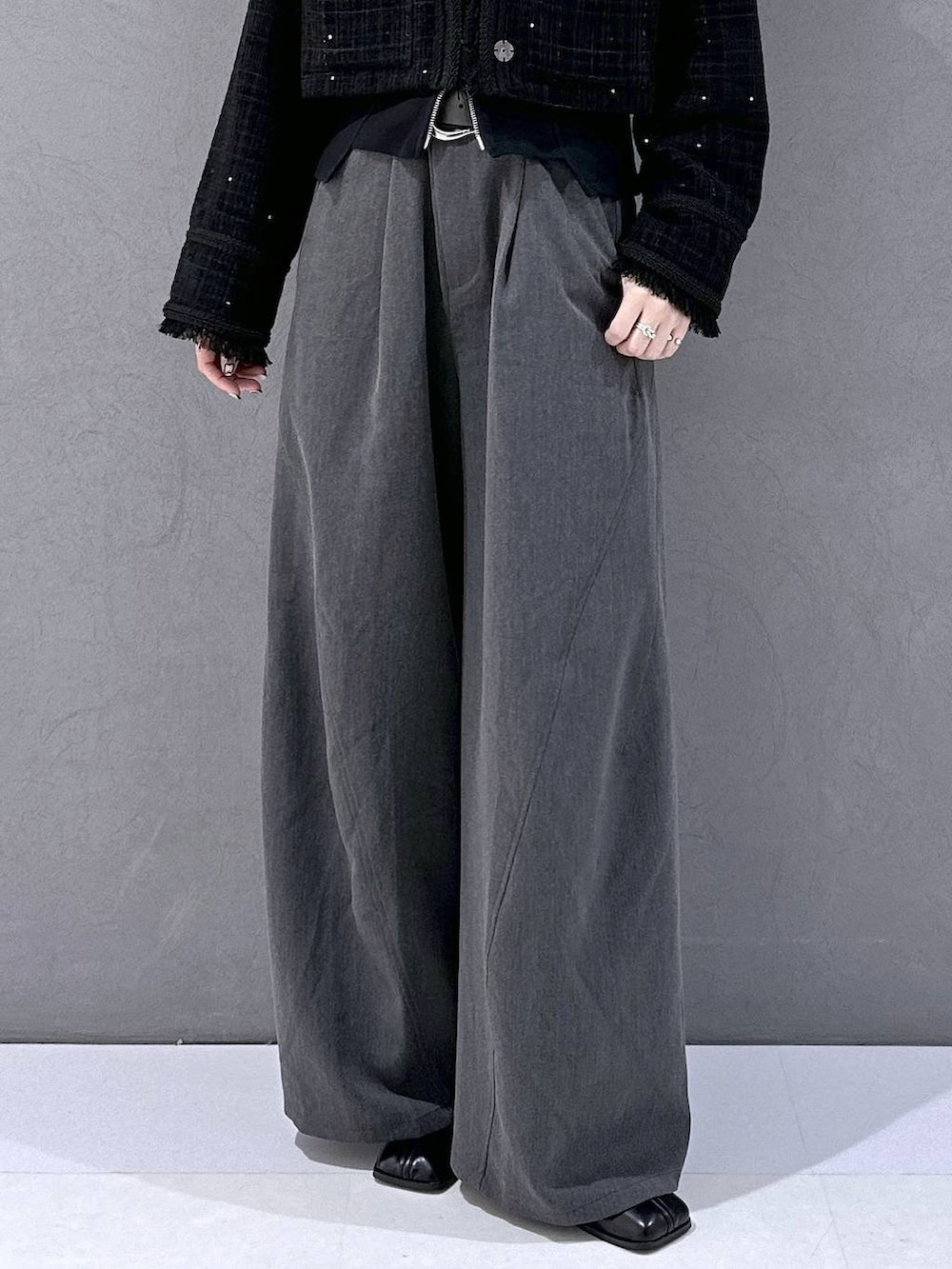 ブラック系のカーディガン/ボレロ、ブラック系のブーツ、グレー系のスラックスを着用したレディースの秋コーディネートの7枚目の写真