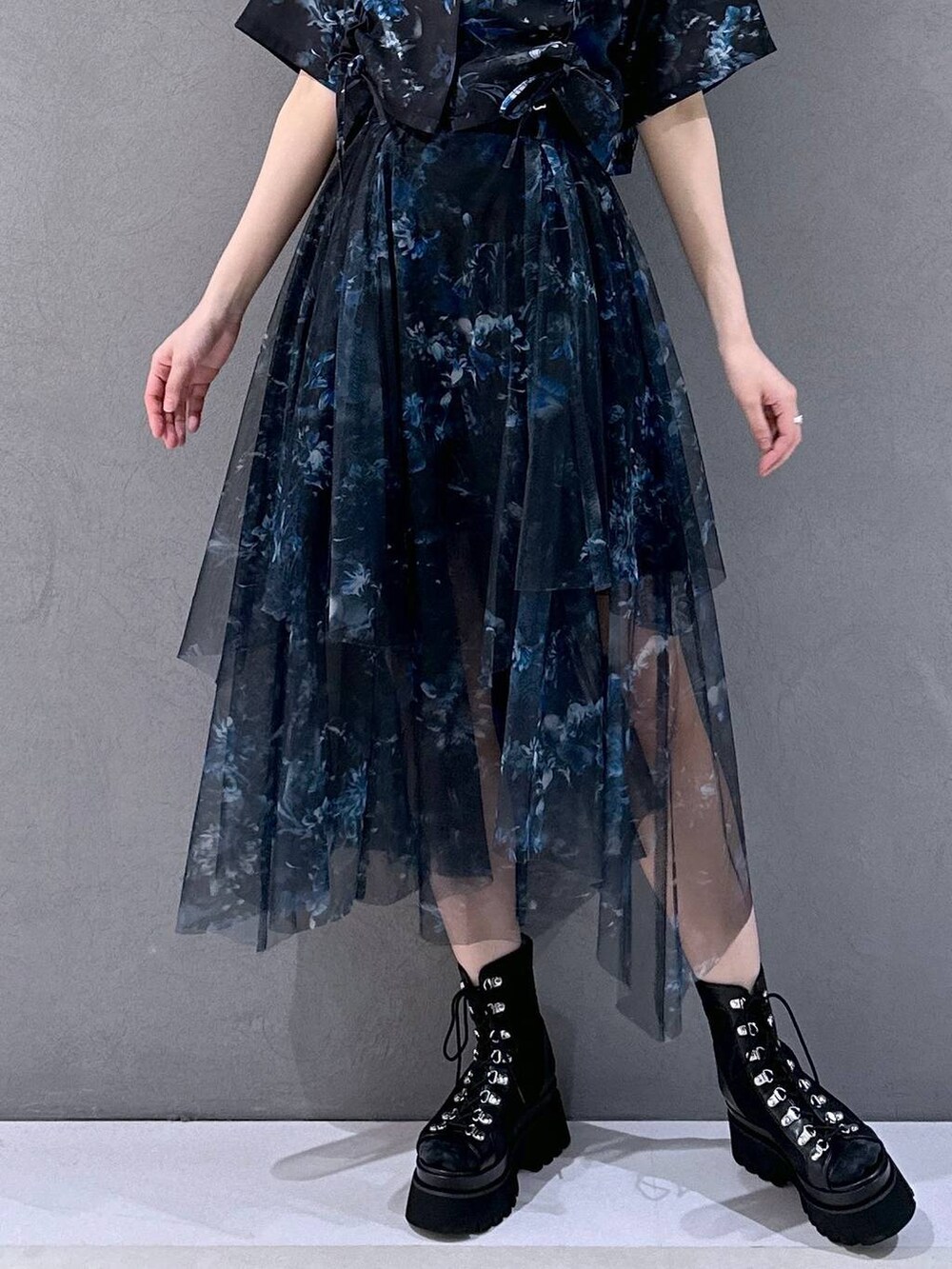 ブラック系のサンダル、ブルー系のシャツ/ブラウス、ブラック系のブローチ/コサージュを着用したレディースの春コーディネートの6枚目の写真