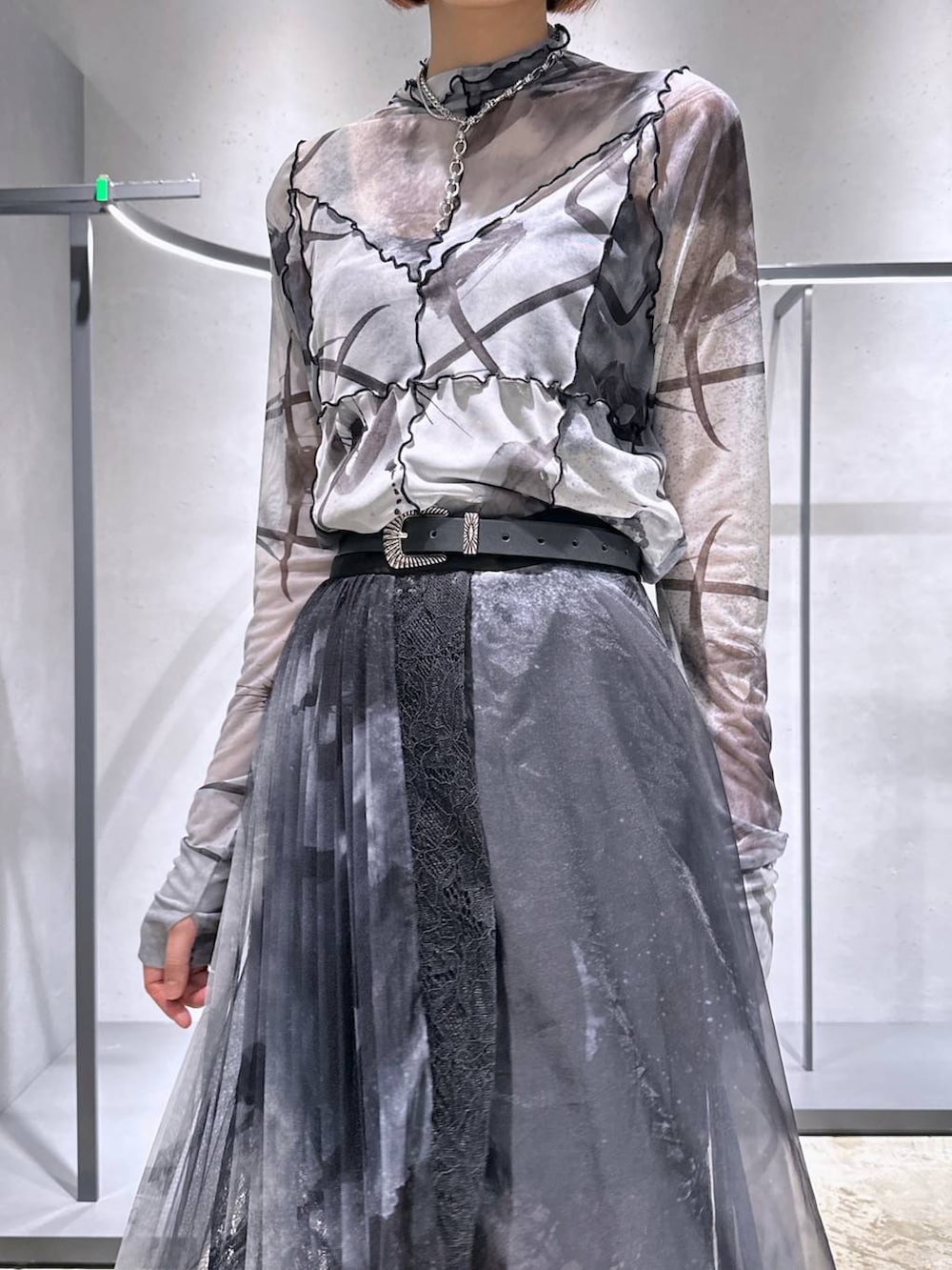 ブラック系のサンダル、ブラック系のスカート、ホワイト系のTシャツ/カットソーを着用したレディースの夏コーディネートの2枚目の写真