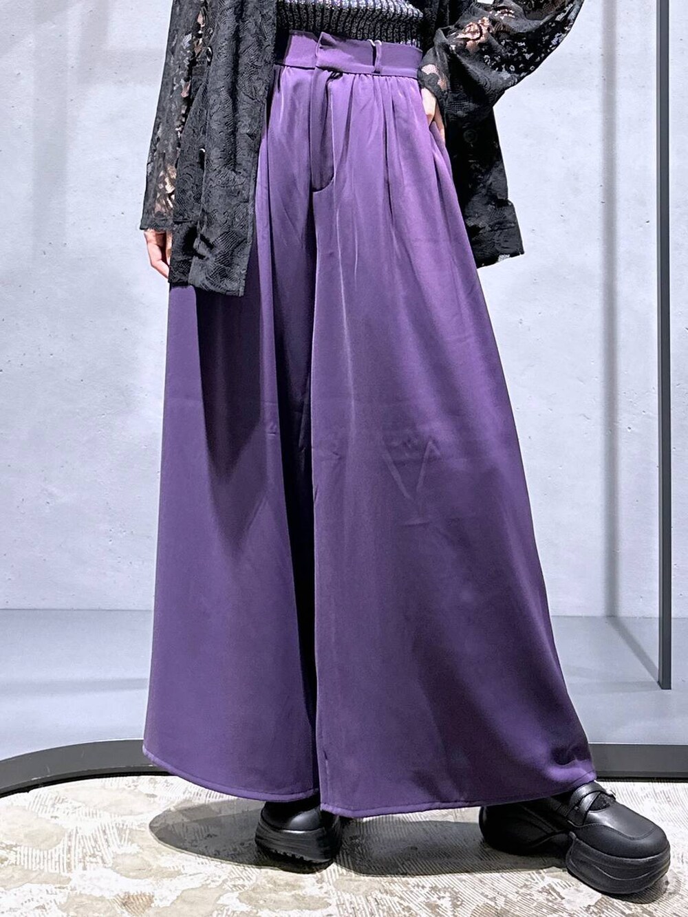 ブラック系のタンクトップ、パープル系のスラックス、ブラック系のブーツを着用したレディースの夏コーディネートの6枚目の写真