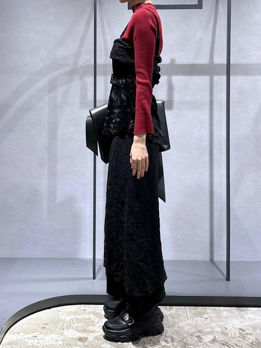 レッド系のニット/セーター、ブラック系のローファー、ブラック系のベストを着用したレディースの夏コーディネートの2枚目の写真