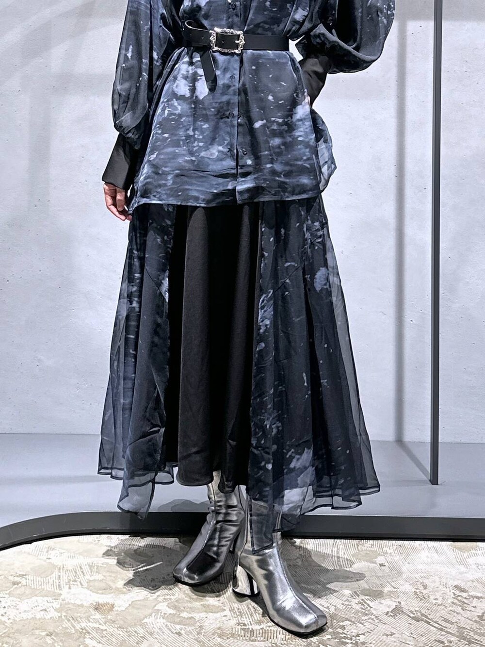 シルバー系のブーツ、ブラック系のニット/セーター、ブラック系のスカートを着用したレディースの秋コーディネートの6枚目の写真