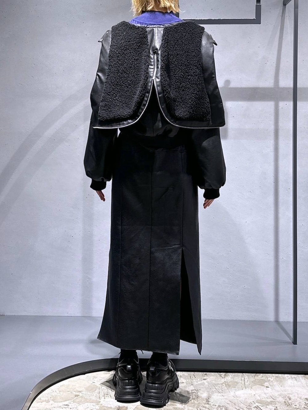 ブラック系のスニーカー、ブラック系のスカート、パープル系のニット/セーターを着用したレディースの冬コーディネートの3枚目の写真