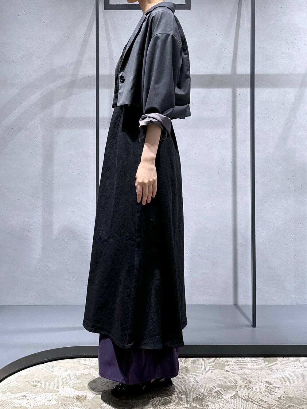 グレー系のテーラードジャケット、ブラック系のパンプス、パープル系のスラックスを着用したレディースの夏コーディネートの2枚目の写真