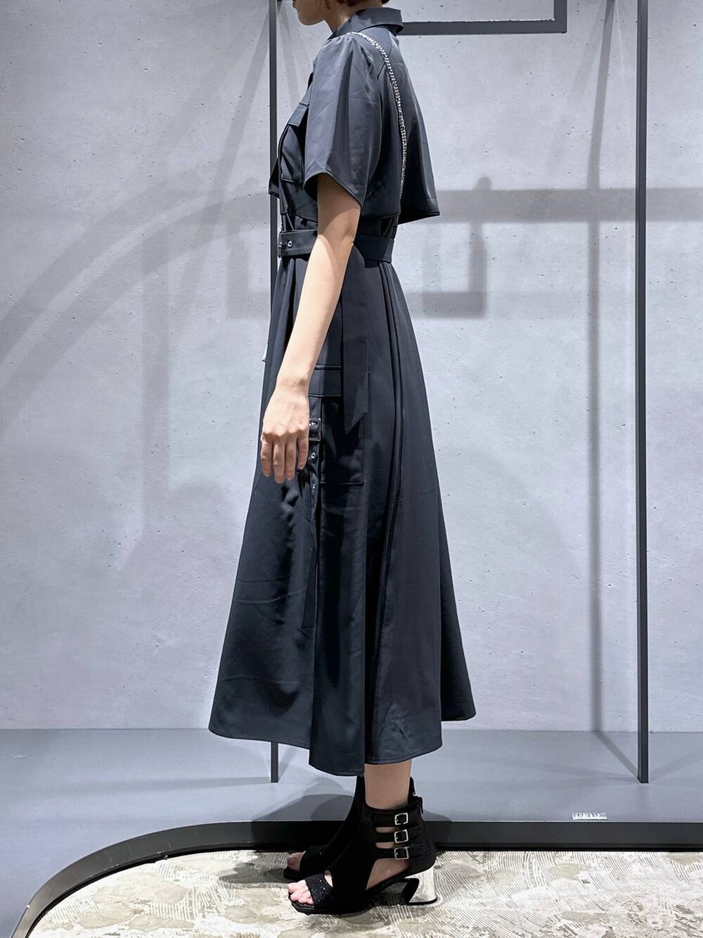 ブラック系のサンダル、シルバー系のショルダーバッグ、グレー系のワンピースを着用したレディースの夏コーディネートの3枚目の写真