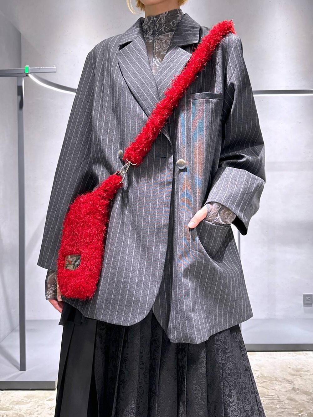 ブラック系のスカート、レッド系のショルダーバッグ、ブラック系のドレスシューズを着用したレディースの秋コーディネートの5枚目の写真