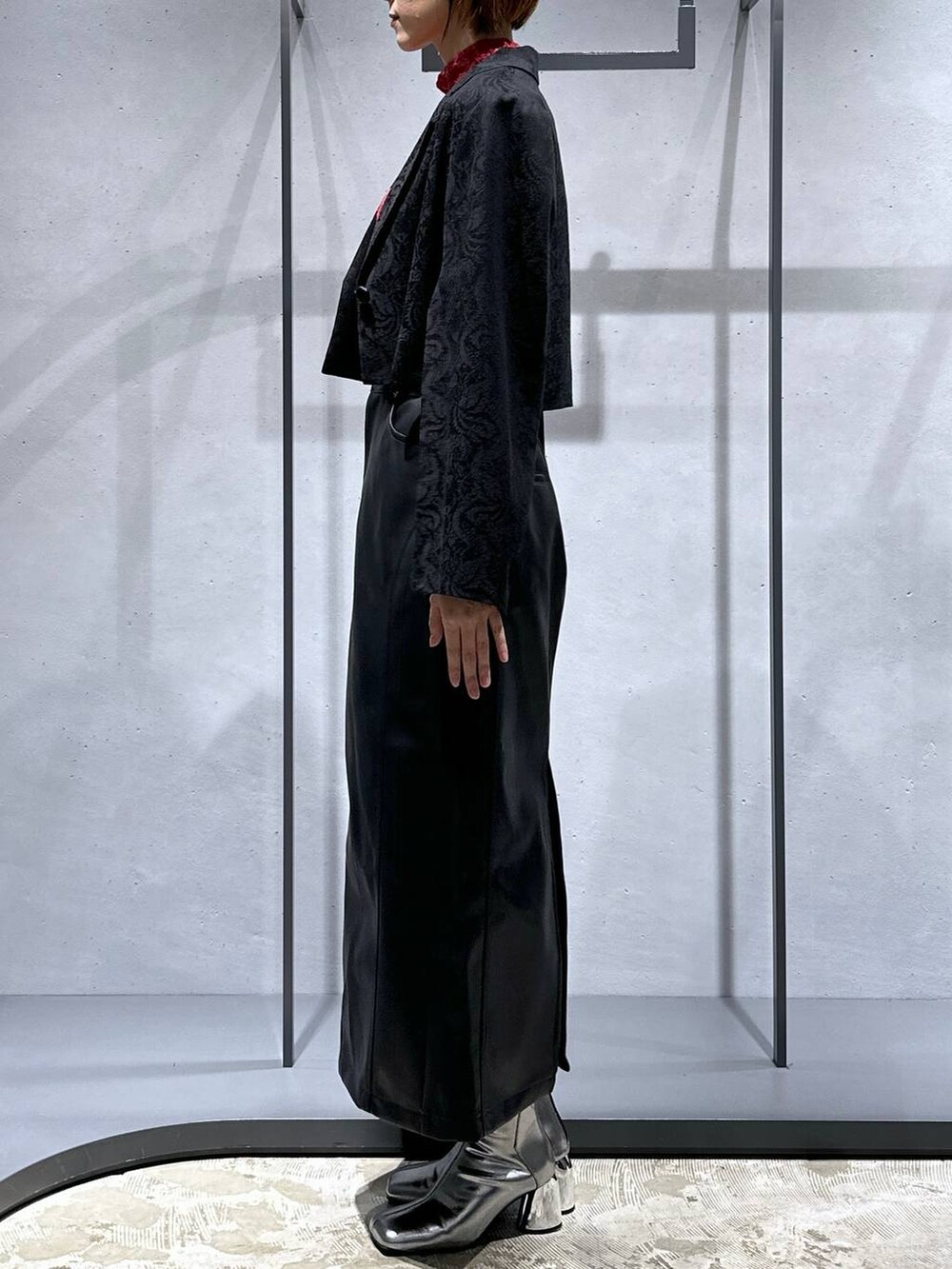 シルバー系のブーツ、レッド系のTシャツ/カットソー、ブラック系のテーラードジャケットを着用したレディースの秋コーディネートの2枚目の写真