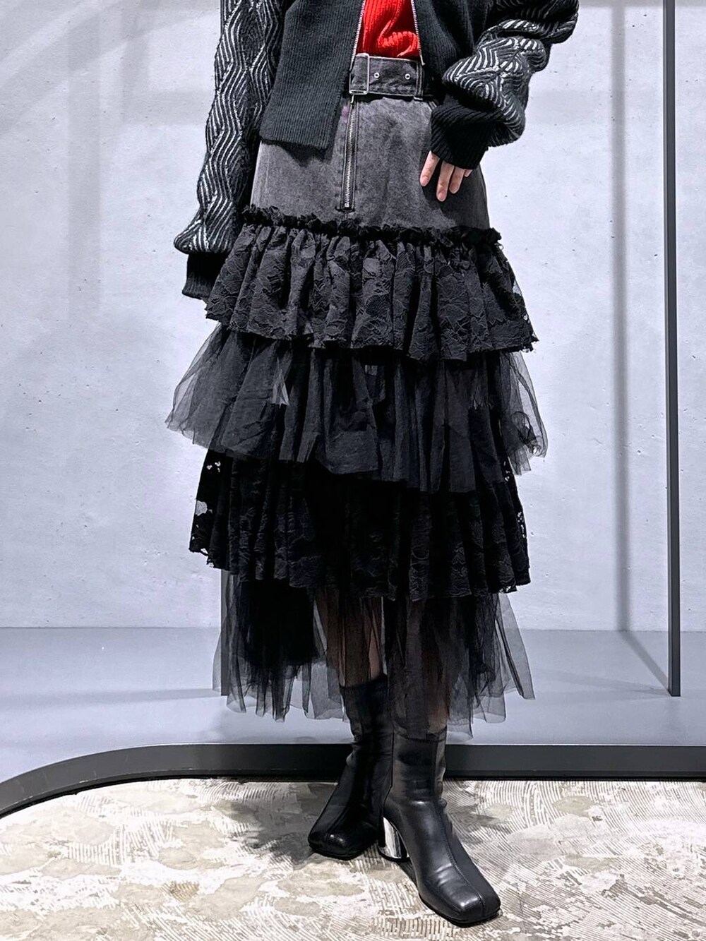 ブラック系のブーツ、ブラック系のカーディガン/ボレロ、レッド系のニット/セーターを着用したレディースの秋コーディネートの6枚目の写真