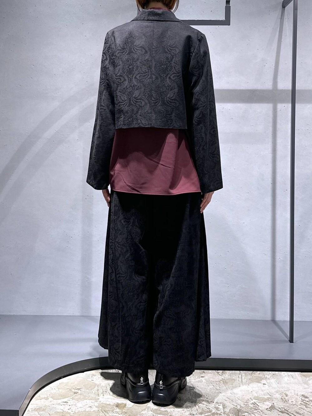 ブラック系のブーツ、ブラック系のテーラードジャケット、レッド系のシャツ/ブラウスを着用したレディースの秋コーディネートの3枚目の写真